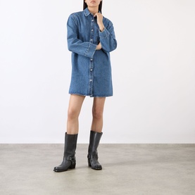 Model wearing Anine Bing blue denim shirt dress with long sleeves and button front, styled with black leather knee-high boots