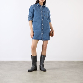 Model wearing Anine Bing blue denim shirt dress, styled with black knee-high boots and a small brown bag.