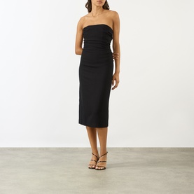 Model wearing Anine Bing black strapless midi dress in viscose blend, styled with brown strappy heeled sandals and gold necklace.