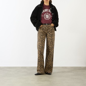 Model wearing Anine Bing black textured jacket, styled with leopard print wide-leg trousers and burgundy graphic T-shirt.