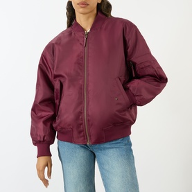 Model wearing Anine Bing Leon Bomber Jacket in burgundy with zip-through fastening, styled with blue jeans.