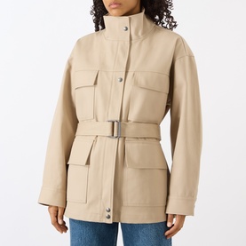 Model wearing Anine Bing Odin Utility Jacket in beige with stand collar, four flap pockets, and matching buckle belt, styled with blue jeans