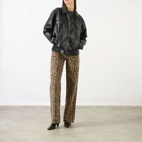Model wearing Anine Bing black oversized leather jacket with chest pockets, styled with leopard print straight-leg trousers and black heeled boots.