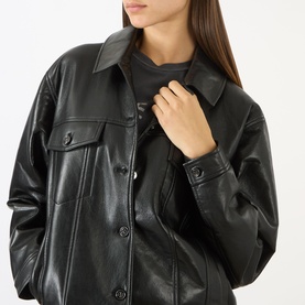 Model wearing Anine Bing black leather jacket with button-front fastening, chest flap pockets, and spread collar, styled with a grey graphic top.
