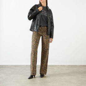 Model wearing Anine Bing black leather jacket with leopard print trousers, graphic tee and black heeled ankle boots.