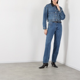 Model wearing Anine Bing washed blue denim cropped jacket, styled with matching blue straight-leg jeans and black heeled ankle boots.