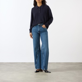 Model wearing Anine Bing Brie Twisted Seam Jeans in Cabana Blue, wide-leg high-rise fit, styled with a navy polo knit and black loafers.