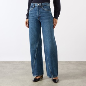 Model wearing Anine Bing Brie Twisted Seam Jeans in Cabana Blue, high-rise wide-leg fit with twisted seam detail, styled with black top and shoes.
