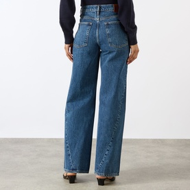 Model wearing Anine Bing Brie Twisted Seam Jeans in Cabana Blue, high-rise wide-leg style with twisted seams, rear view, styled with dark top.