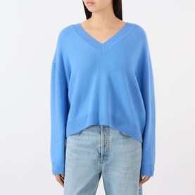 Model wearing Anine Bing blue cashmere V-neck sweater with dropped shoulders, styled with light-wash jeans.