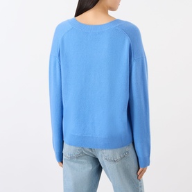 Model wearing Anine Bing blue cashmere knit sweater, back view, styled with light wash jeans.