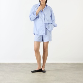 Model wearing Anine Bing Essie Striped Shirt in Washed Blue with matching shorts and black ballet flats