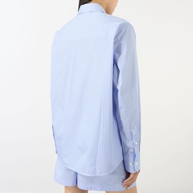 Model wearing Anine Bing Essie Striped Shirt in Washed Blue, showing back view with dropped shoulders and double button cuffs, styled with matching