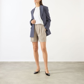 Model wearing Anine Bing multi-tone tailored shorts with white tee and oversized blue blazer, styled with black kitten heel mules.