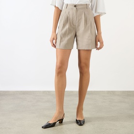 Model wearing Anine Bing shorts in multi, styled with black kitten heel mules and a white top.