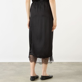 Model wearing Anine Bing black silk-blend midi skirt, rear view, lace hem trim, styled with black ballet flats.