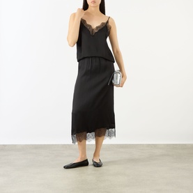 Model wearing Anine Bing black silk-blend midi skirt with lace hem, styled with matching cami top and black ballet flats.
