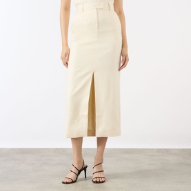 Model wearing Anine Bing cream midi skirt with front split, paired with black strappy heeled sandals.
