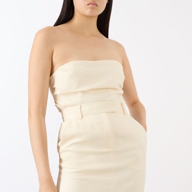 Model wearing Anine Bing cream skirt with matching strapless top, fitted silhouette with front belt detail, viscose blend fabric.