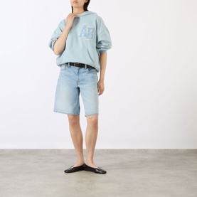 Model wearing Anine Bing Harvey Logo Drawstring Hoodie in blue, styled with light wash denim shorts and black flat shoes.