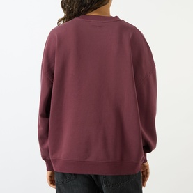 Model wearing Anine Bing burgundy cotton crew neck sweat top, back view, styled with grey jeans.