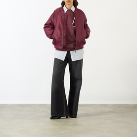 Model wearing Anine Bing burgundy sweat top, styled with an oversized bomber jacket and wide-leg black trousers.