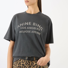 Model wearing Anine Bing washed black logo T-shirt with leopard print trousers and black belt