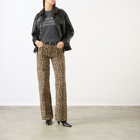 Model wearing Anine Bing Washed Black graphic T-shirt, styled with leopard-print flared jeans and black leather jacket.