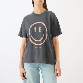 Model wearing Anine Bing washed grey oversized T-shirt with pink smiley face AB graphic print, styled with light blue jeans.