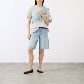 Model wearing Anine Bing Cade Wave Logo T-Shirt in Heather Grey with light blue denim shorts and black ballet flats, carrying a denim bag.