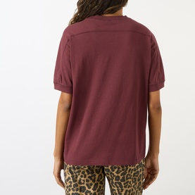 Model wearing Anine Bing burgundy cotton T-shirt, back view, styled with leopard-print trousers