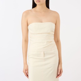 Model wearing Anine Bing cream strapless structured top with ruched detail, styled with a matching cream midi skirt.