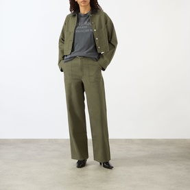 Model wearing Anine Bing Ivan Paris Stencil Top in black with khaki wide-leg trousers and matching jacket, black heeled mules.