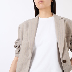 Model wearing Anine Bing white cotton T-shirt, styled with a light beige linen blazer