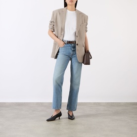 Model wearing Anine Bing white cotton T-shirt, styled with a beige blazer, light blue straight-leg jeans and black heeled mules
