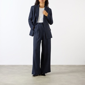 Model wearing Anine Bing Paola Tonal Striped Trousers in Navy Pinstripe, wide-leg with front pleats, styled with matching navy blazer and white top.