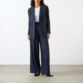 Model wearing Anine Bing Paola Tonal Striped Trousers in navy pinstripe, wide-leg with front pleats, styled with matching blazer and white top.