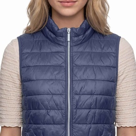 Model wearing Betty Barclay Quilted Zipped Gilet in Blue Horizon, stand-up collar, two-way zip, styled with cream textured top
