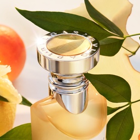 Bulgari EDT in pale amber glass bottle with silver cap, styled with citrus fruit and green leaves