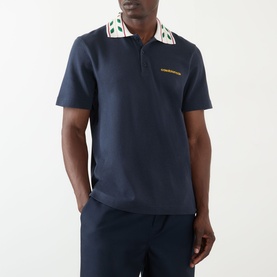 Model wearing Casablanca Laurel Piqu&eacute; Polo Shirt in navy with laurel-embellished collar, paired with matching navy trousers.