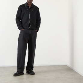 Model wearing Casablanca black cotton zip-up jacket, styled with dark wide-leg trousers and black loafers.