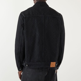 Model wearing Casablanca black cotton jacket, rear view, featuring allover woven texture pattern and tan leather logo patch at hem.