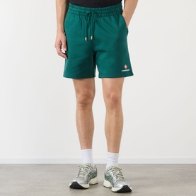 Model wearing Casablanca Logo Sweat Shorts in green with elasticated drawstring waist and small logo print, styled with white socks and trainers.