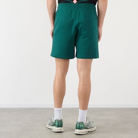 Model wearing Casablanca Logo Sweat Shorts in green, rear view, styled with white socks and green trainers.