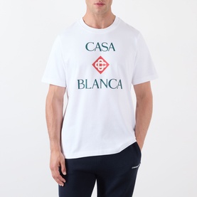 Model wearing Casablanca Diamond Logo T-Shirt in white with stacked Casa Blanca diamond graphic print, styled with navy trousers.