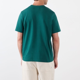Model wearing Casablanca Diamond Logo T-Shirt in green, rear view, short sleeves, straight hem, styled with ecru trousers.