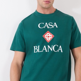 Model wearing Casablanca Diamond Logo T-Shirt in green with stacked Casa Blanca logo and red diamond graphic print at chest
