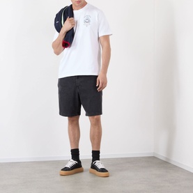Model wearing Casablanca Classic Logo Graphic T-Shirt in white with dark grey shorts, black socks and tan trainers, carrying a bag over shoulder.