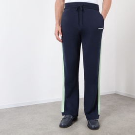 Model wearing Casablanca Logo Merino Wool Track Pants in navy with green contrast side stripe, drawstring waist, straight-cut leg