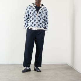 Model wearing Casablanca Monogram Logo Zip Sweatshirt in CC Monogram print, styled with navy wide-leg trousers and black loafers.